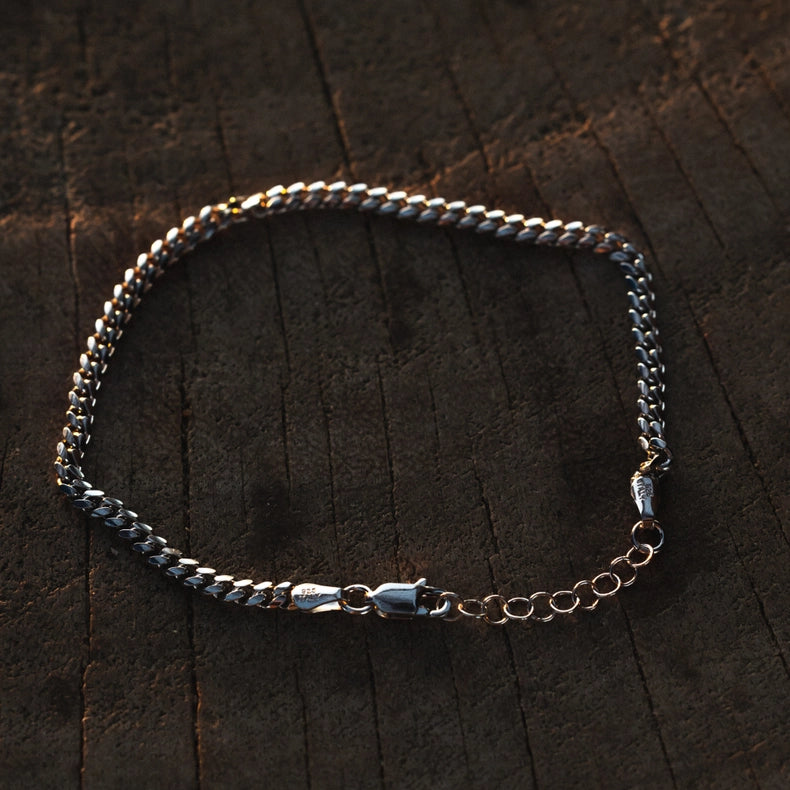 925 sterling silver Cuban bracelet on a dark wooden surface