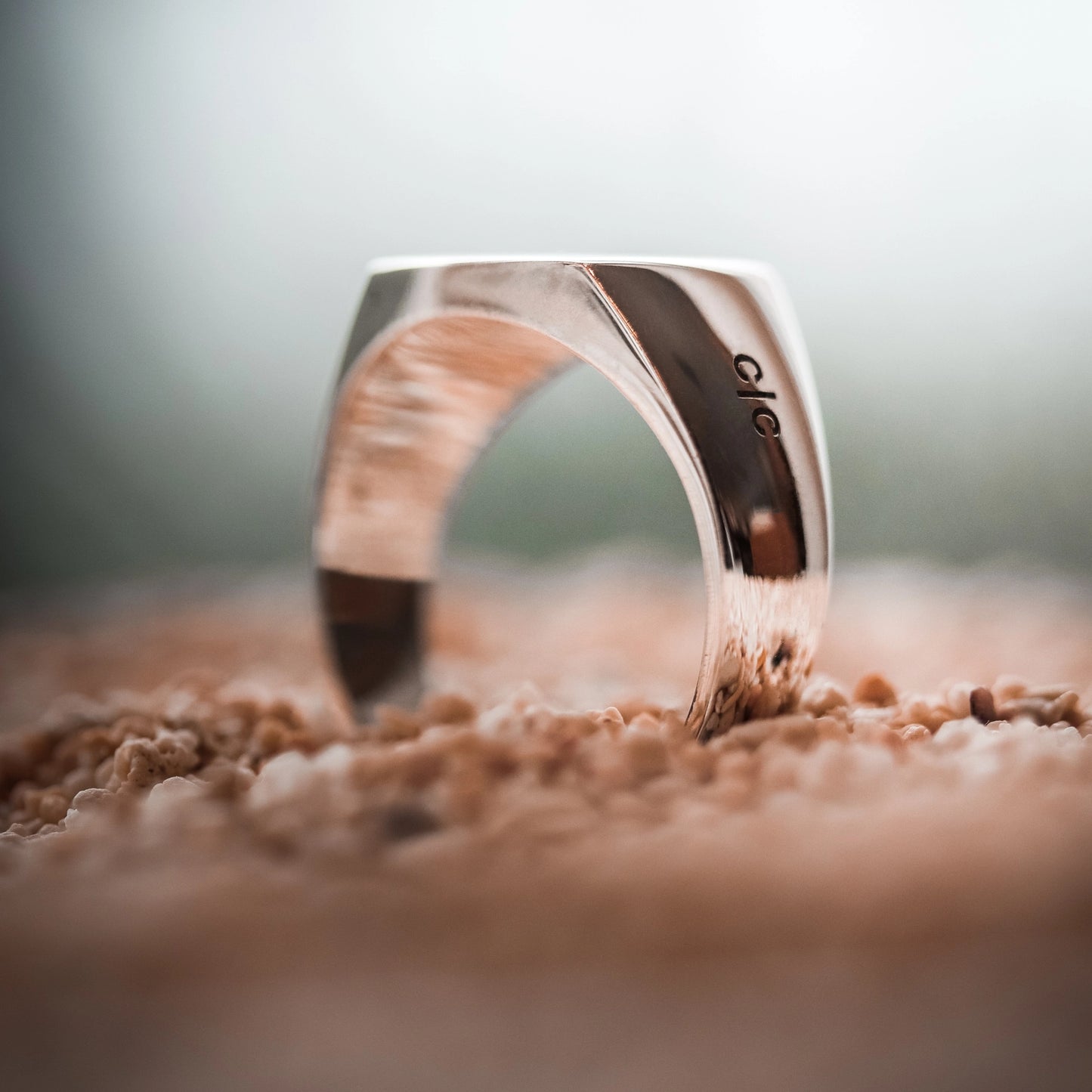 925 sterling silver signet ring on a sand background