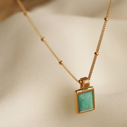 18k gold-plated necklace with a square amazonite blue gemstone pendant on a beige background