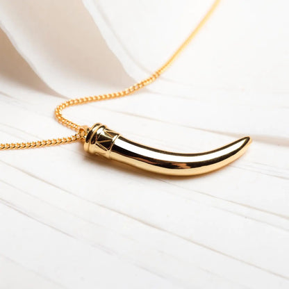 Men's 18k gold plated horn necklace displayed on a table