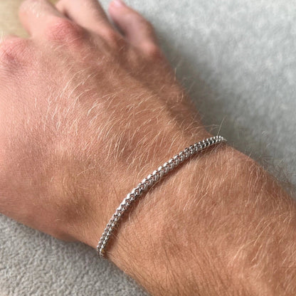 925 sterling silver Cuban bracelet on a man's wrist with a neutral background