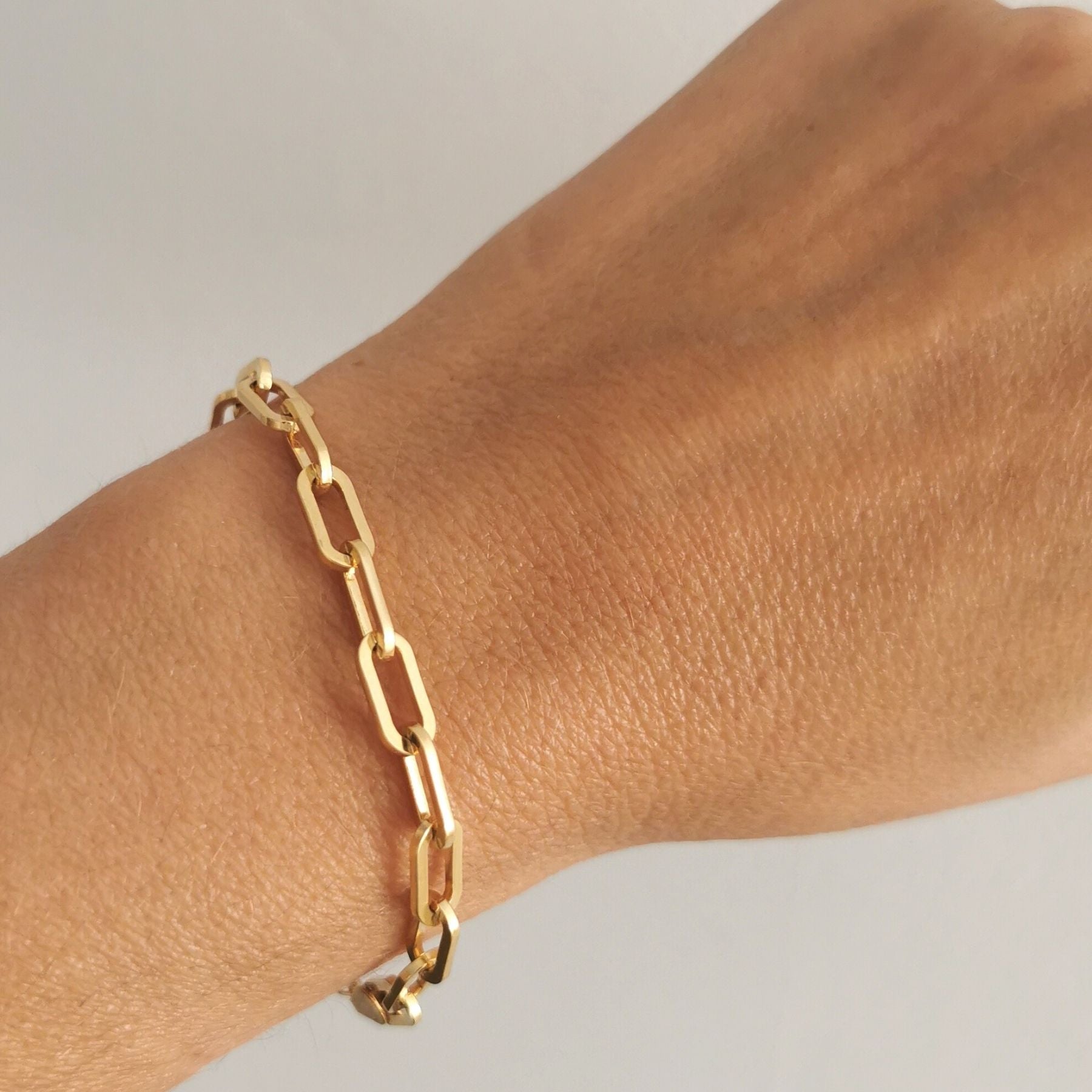 A woman wearing a heavy 18k gold-plated chain bracelet