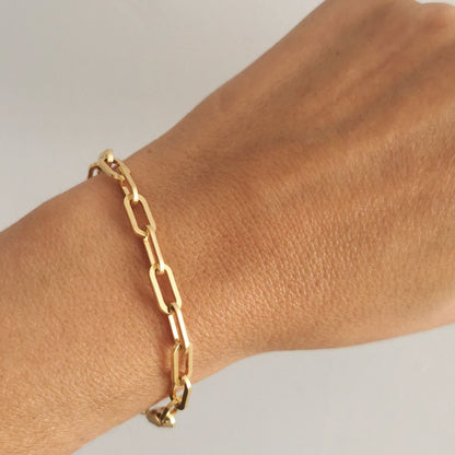 A woman wearing a heavy 18k gold-plated chain bracelet