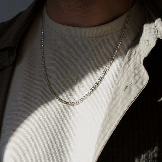 Model wearing a 925 sterling silver cuban necklace with sun reflecting off part of the piece
