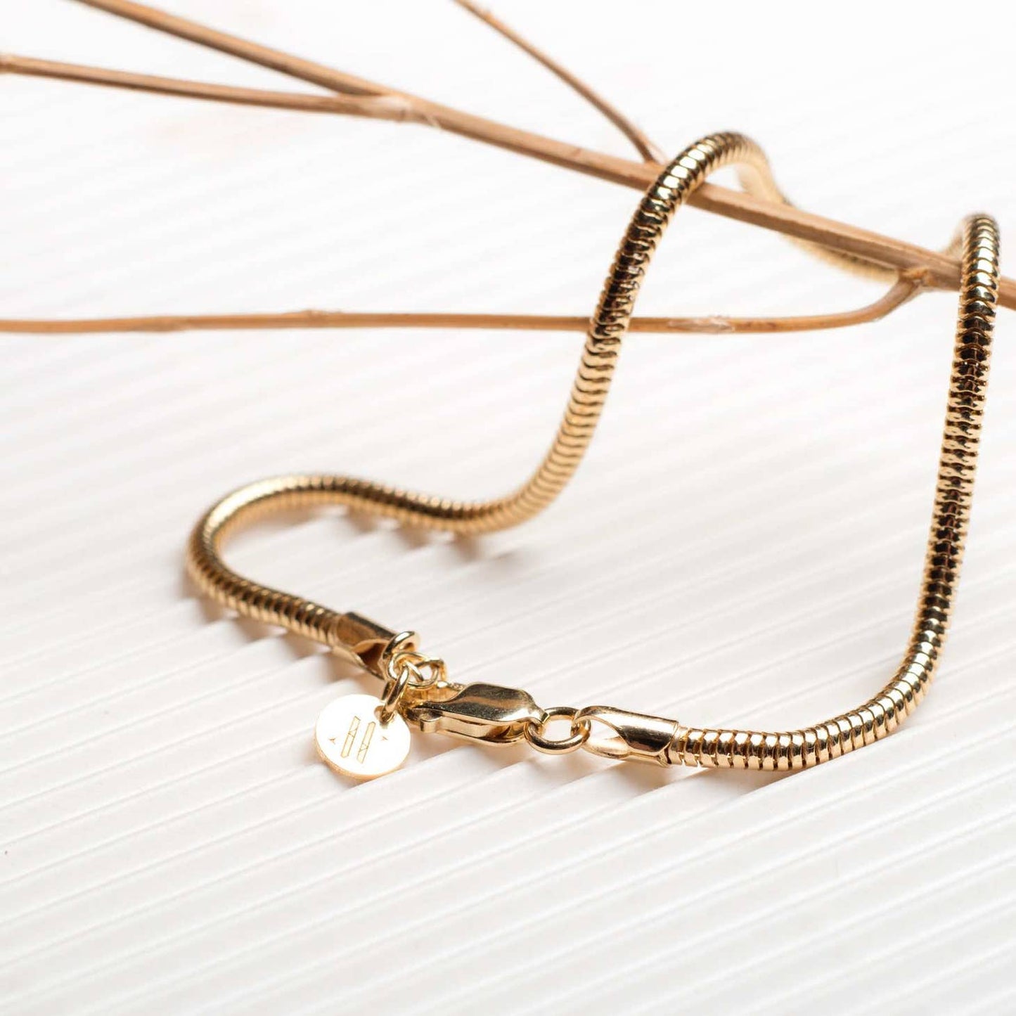 Men's 18k gold plated mamba bracelet being displayed on a white background