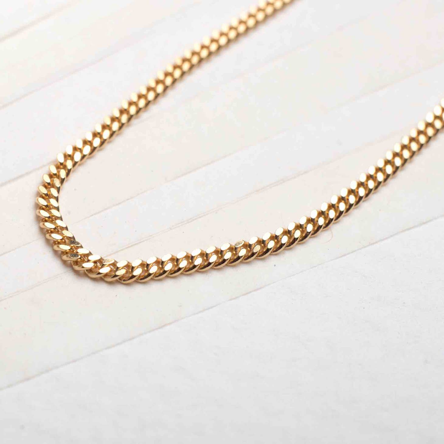 18k men's gold plated necklace displayed on table