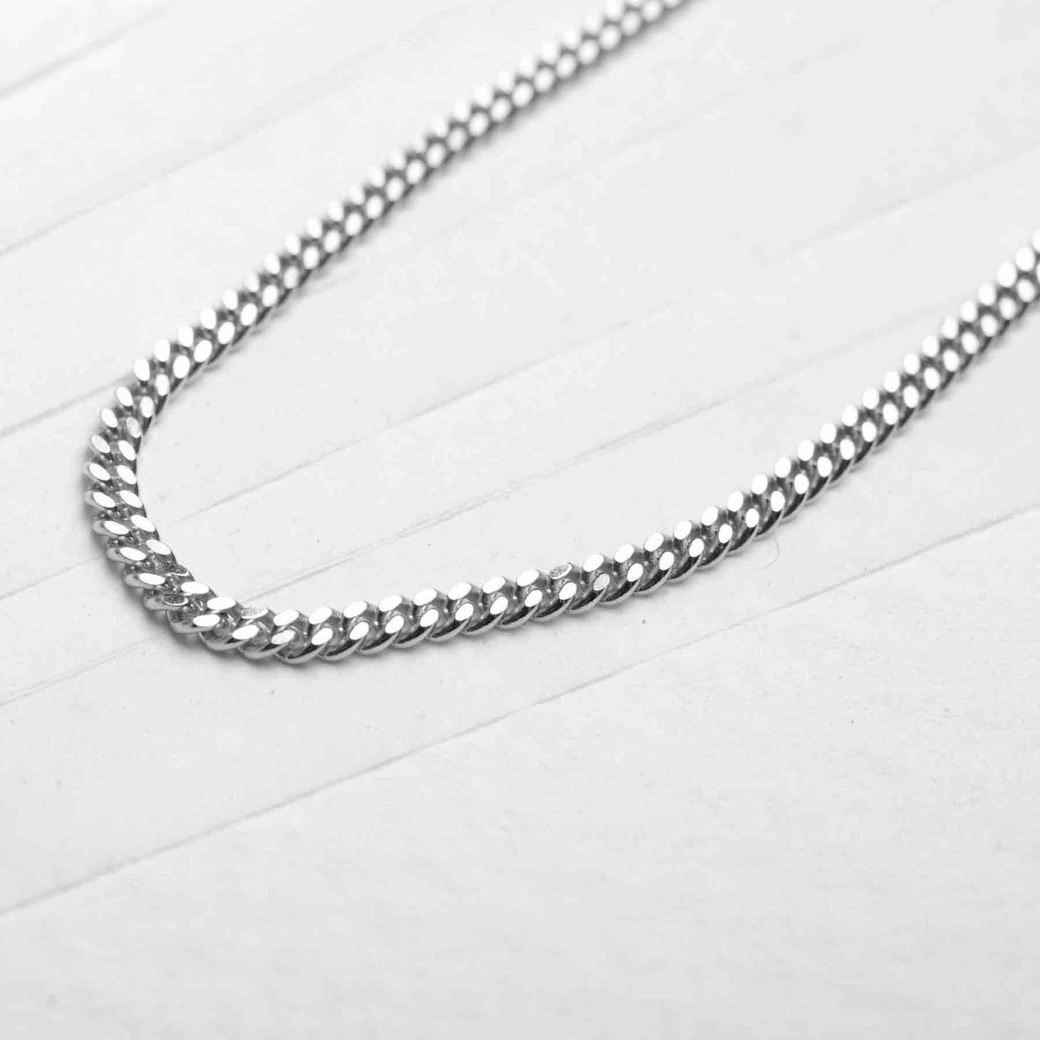 Men's 925 sterling silver chain necklace displayed on a white table